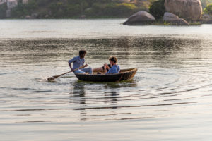 Coracle rows with passengers over reservoir Coracle rows with passengers over reservoir